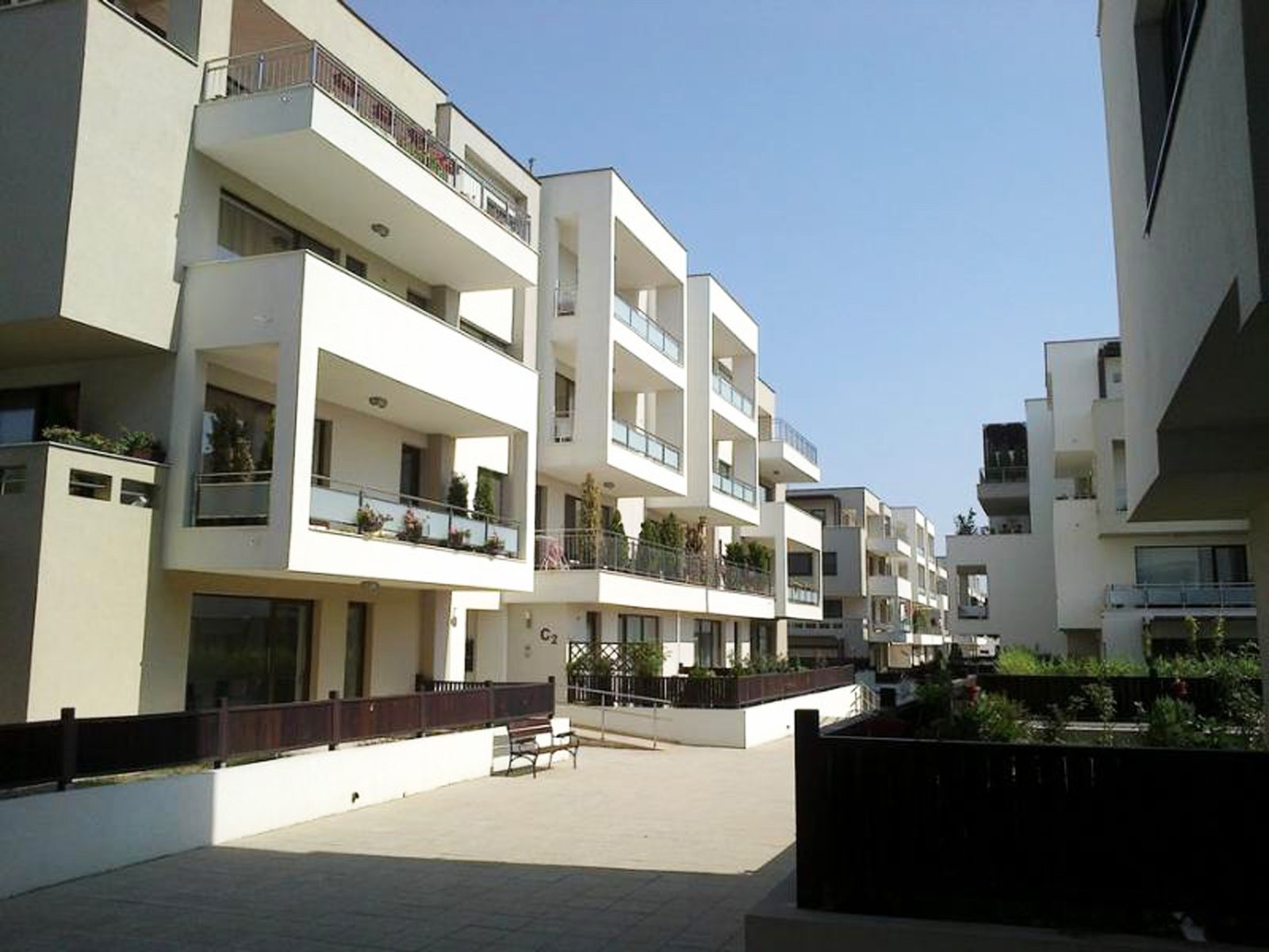Complexul construit, văzut din aleea interioară: balcoanele locuite și jardinierele